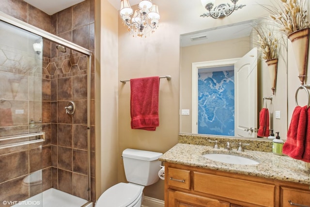 bathroom featuring toilet, a shower with door, and vanity