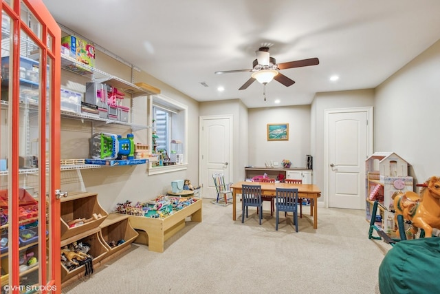 rec room with ceiling fan and light colored carpet