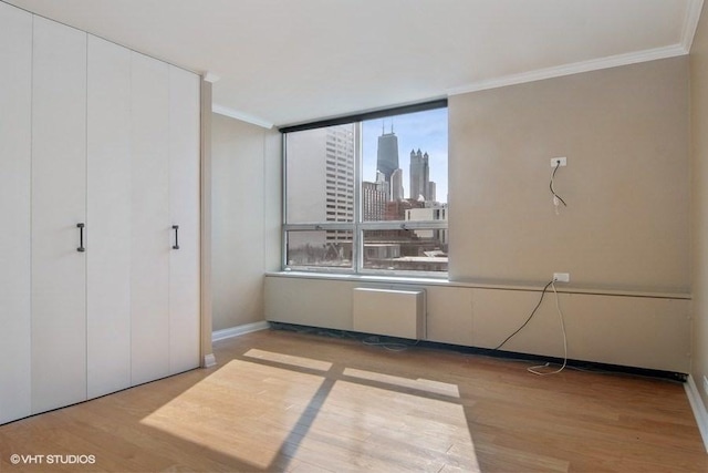 unfurnished bedroom featuring ornamental molding and light hardwood / wood-style floors