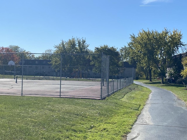 view of tennis court with a lawn