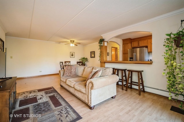 living room featuring a baseboard heating unit, ceiling fan, light hardwood / wood-style floors, and ornamental molding