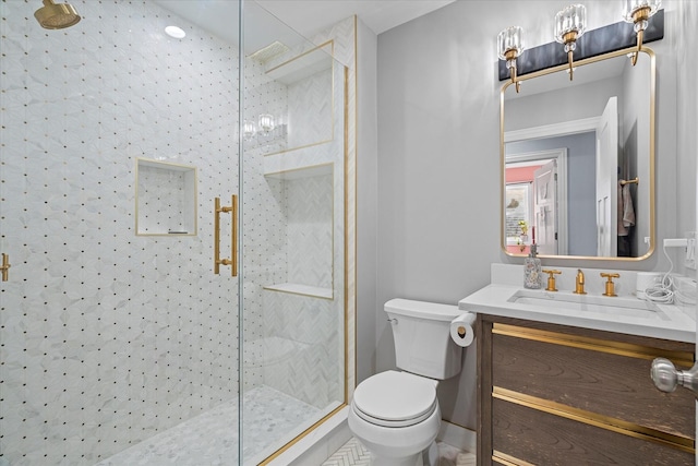 bathroom with vanity, toilet, and a tile shower