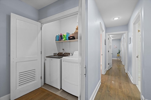 laundry room with light hardwood / wood-style floors and washing machine and clothes dryer