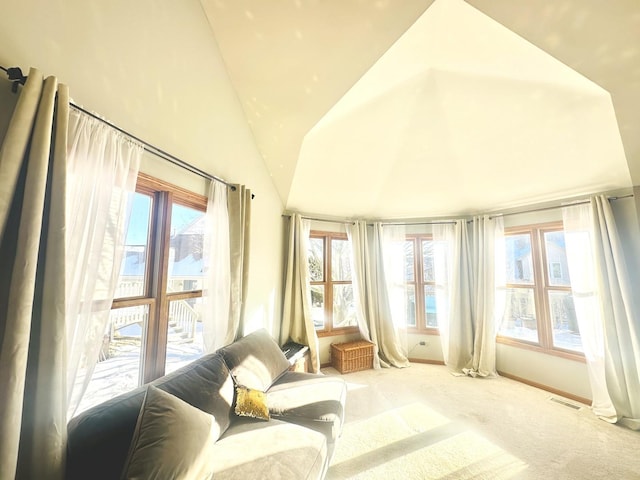 sitting room with lofted ceiling, light carpet, and plenty of natural light