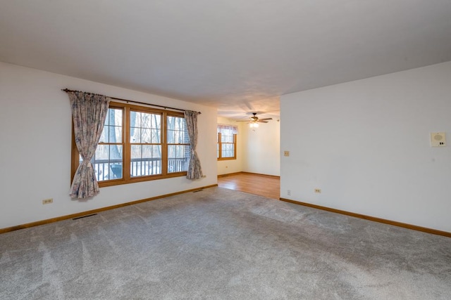 spare room with ceiling fan and light colored carpet