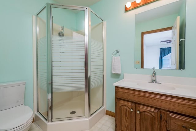 bathroom featuring toilet, vanity, and a shower with door