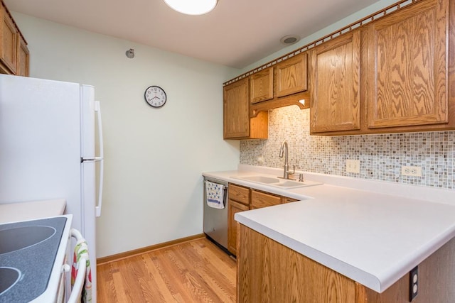 kitchen with dishwasher, white fridge, decorative backsplash, sink, and light hardwood / wood-style flooring