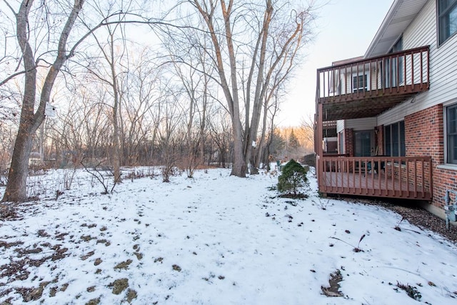 yard covered in snow featuring a wooden deck