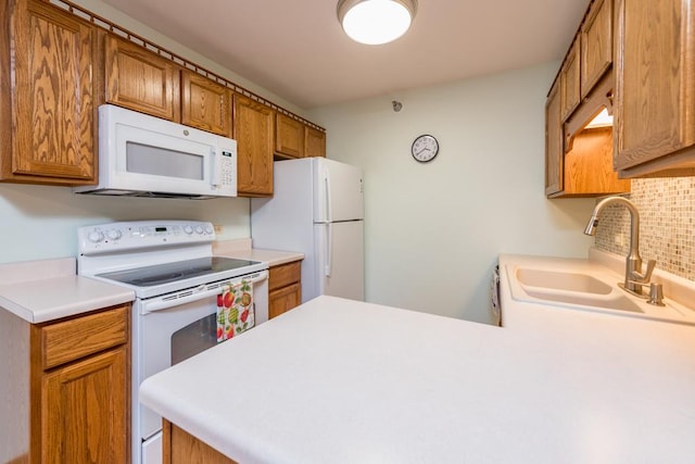 kitchen with kitchen peninsula, backsplash, sink, and white appliances