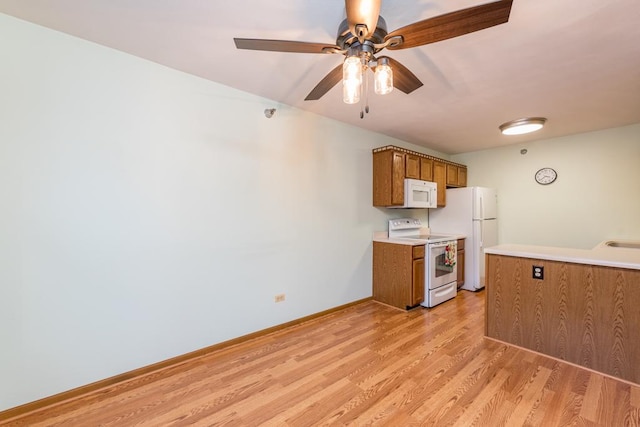 kitchen featuring ceiling fan, sink, light hardwood / wood-style flooring, and white appliances