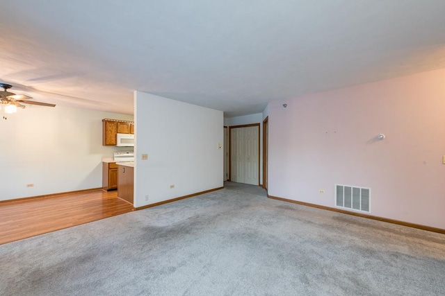 empty room with ceiling fan and light carpet