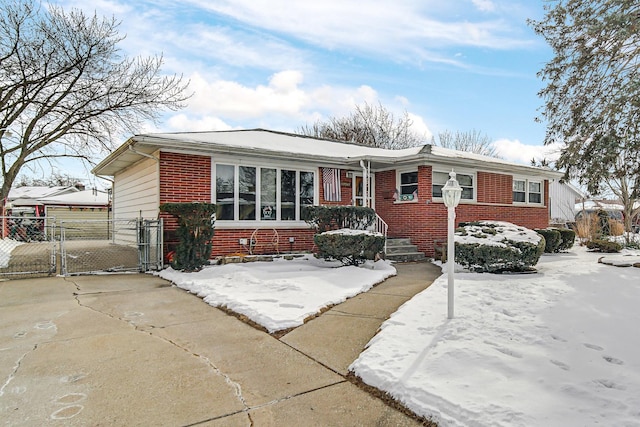 single story home featuring a gate, brick siding, and fence