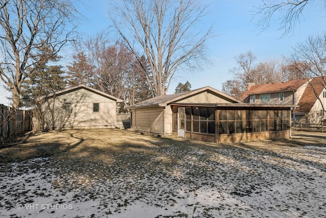 snow covered property featuring a sunroom