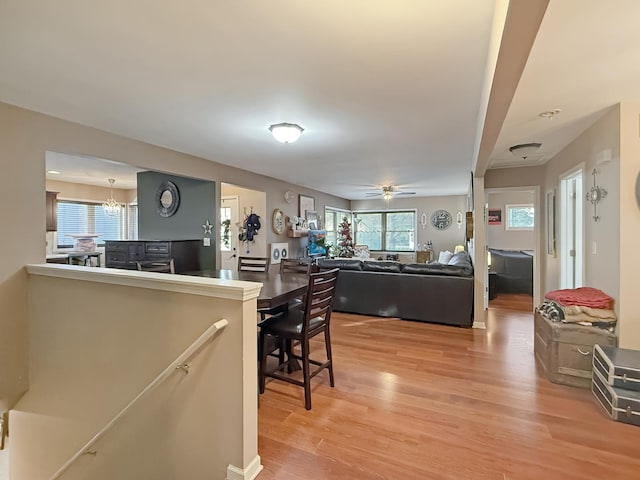 kitchen featuring ceiling fan with notable chandelier, hardwood / wood-style flooring, and a wealth of natural light