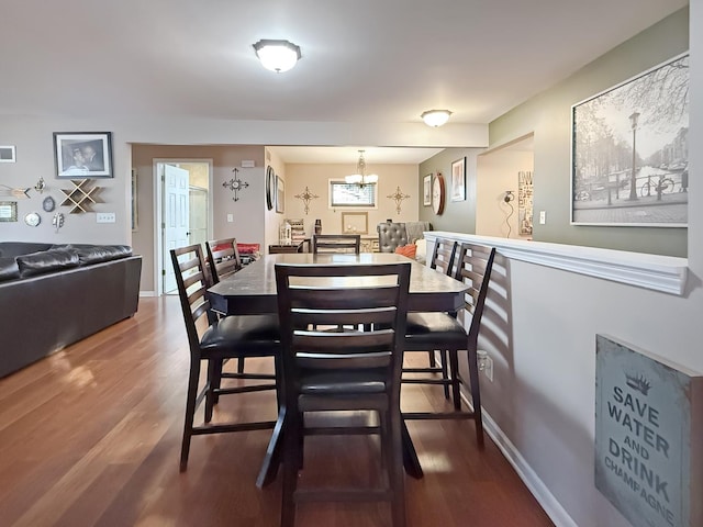 dining space featuring wood-type flooring and a chandelier