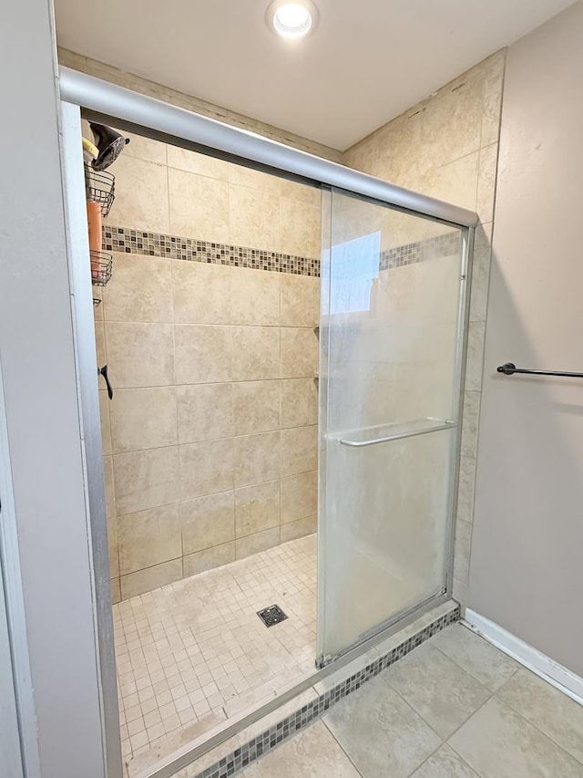 bathroom with an enclosed shower and tile patterned floors