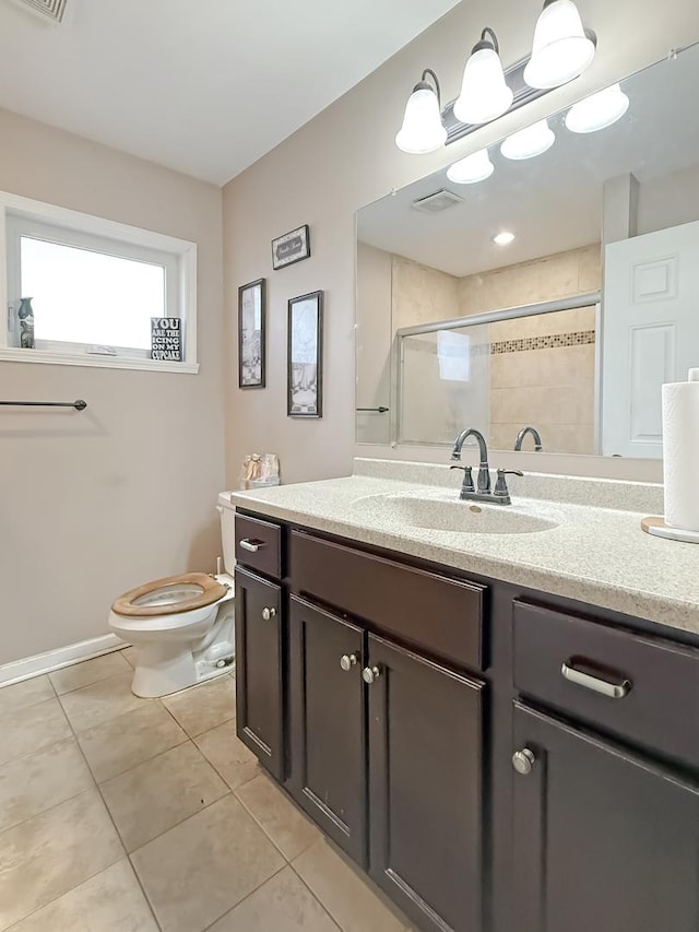 bathroom featuring toilet, an enclosed shower, tile patterned floors, and vanity