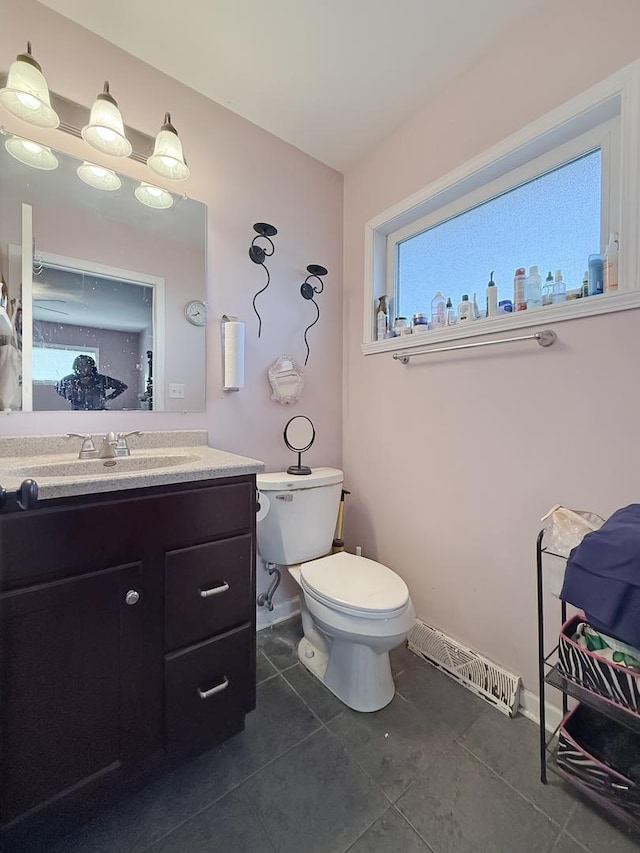 bathroom with toilet, tile patterned floors, and vanity