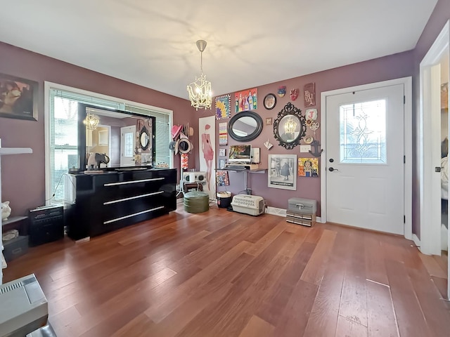 misc room with hardwood / wood-style floors and an inviting chandelier