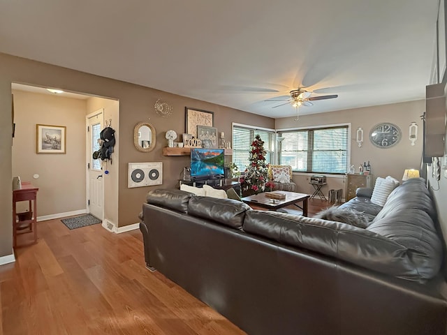 living room featuring ceiling fan and light hardwood / wood-style flooring