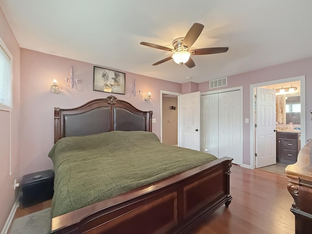 bedroom featuring a closet, connected bathroom, wood-type flooring, and ceiling fan