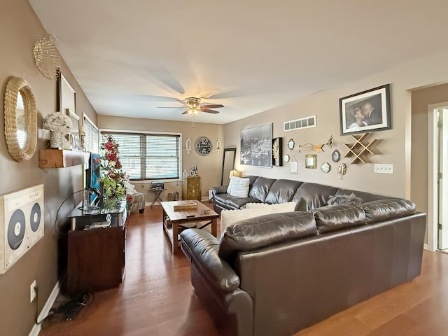 living room featuring dark wood-type flooring and ceiling fan