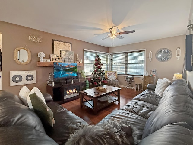 living room featuring dark wood-type flooring and ceiling fan