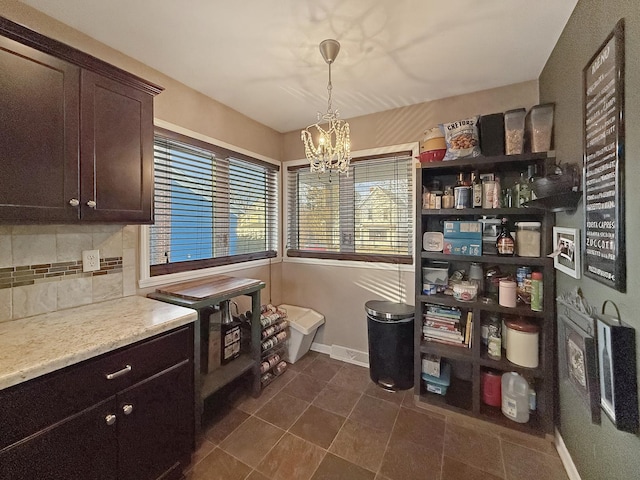 interior space with an inviting chandelier, dark brown cabinetry, decorative backsplash, and hanging light fixtures