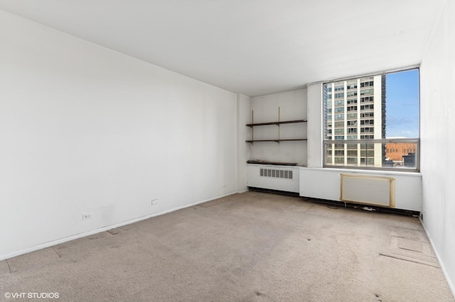 empty room featuring light carpet and radiator