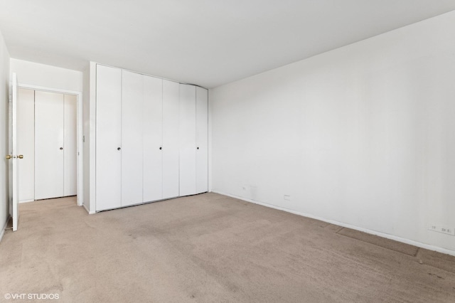 unfurnished bedroom with a closet and light carpet