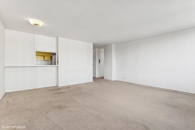 unfurnished living room featuring light colored carpet