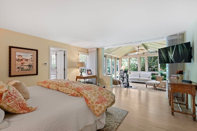 bedroom with wood finished floors and vaulted ceiling