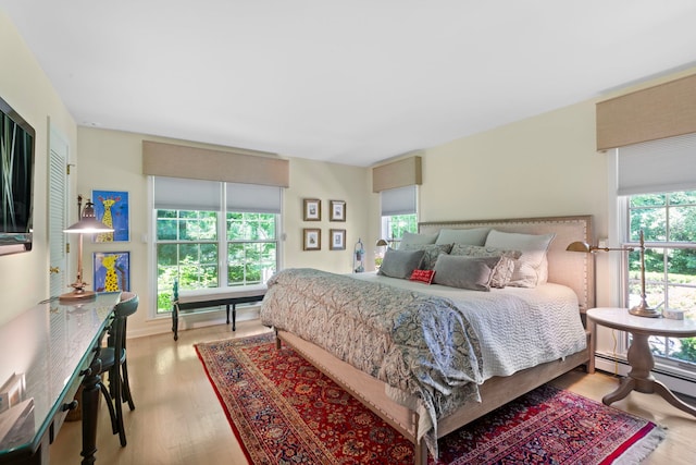 bedroom featuring wood finished floors and a baseboard radiator