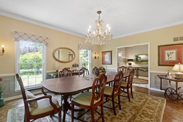 dining room featuring visible vents, wainscoting, an inviting chandelier, and ornamental molding