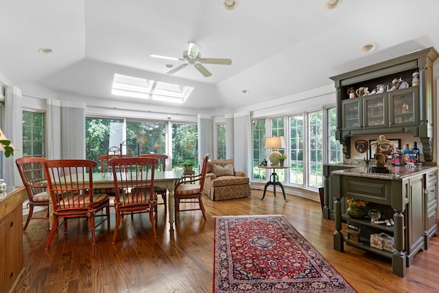 sunroom / solarium with vaulted ceiling with skylight and a ceiling fan