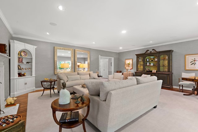 living area featuring light wood-style flooring, recessed lighting, a high end fireplace, and ornamental molding