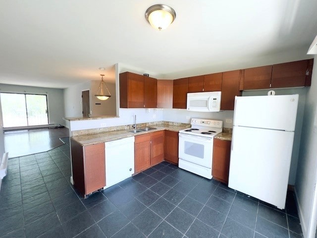 kitchen with white appliances, hanging light fixtures, and sink