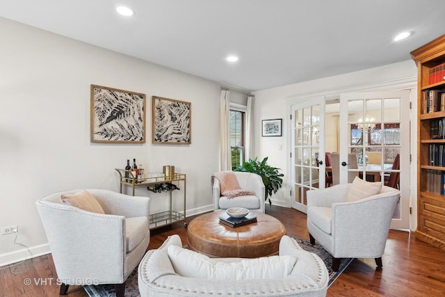 sitting room featuring dark wood-type flooring and a notable chandelier