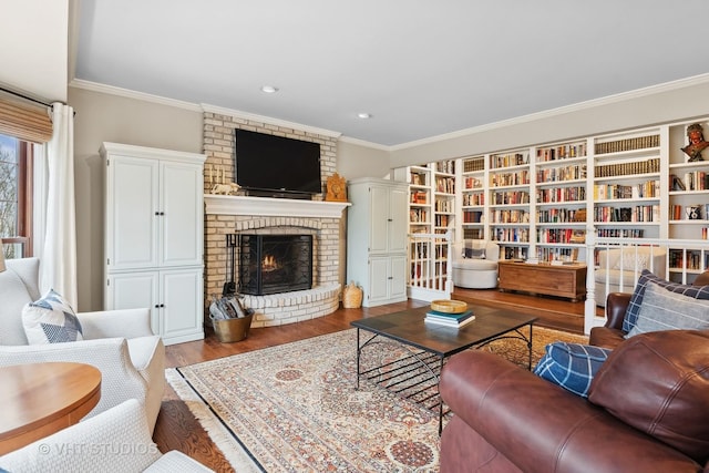 living room with wood-type flooring, ornamental molding, and a fireplace