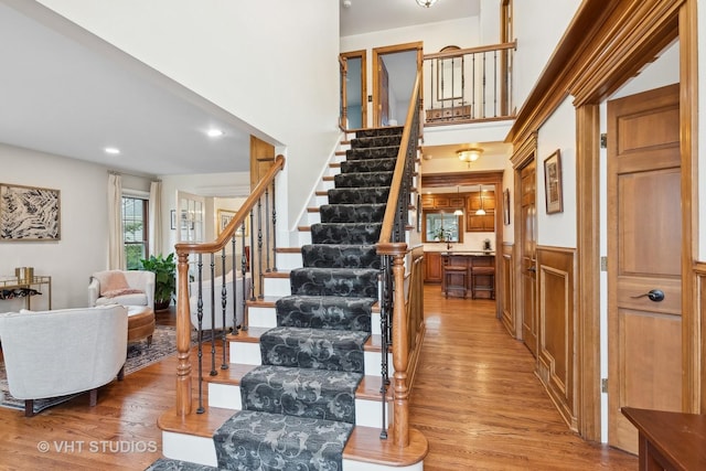 stairs featuring hardwood / wood-style flooring and a towering ceiling