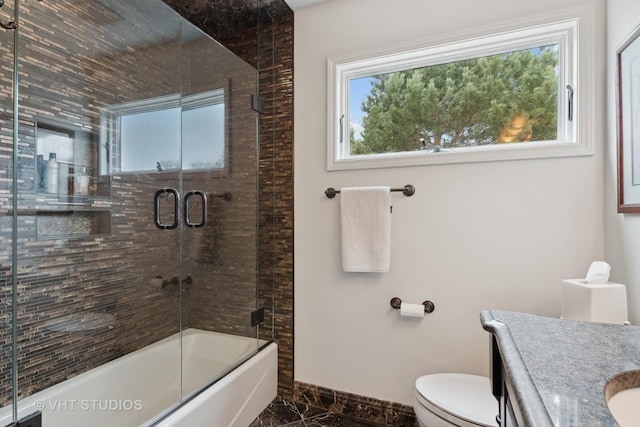 full bathroom with vanity, bath / shower combo with glass door, and toilet