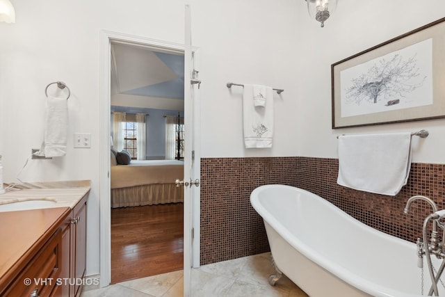 bathroom with vanity, tile patterned flooring, tile walls, and a washtub