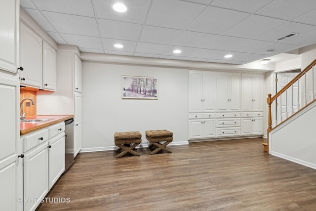 interior space featuring white cabinetry, wood-type flooring, dishwasher, and sink