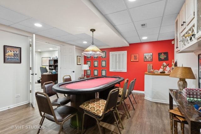 playroom featuring a drop ceiling and dark wood-type flooring