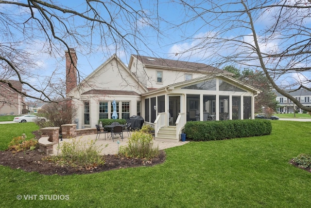 rear view of house with a sunroom, a yard, and a patio area