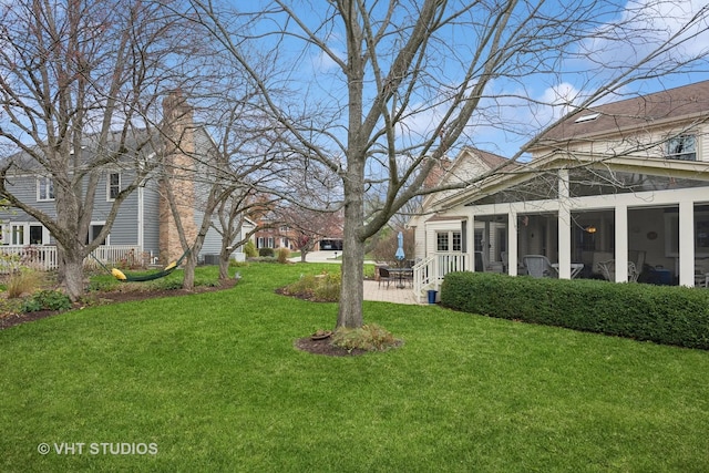 view of yard featuring a patio and a sunroom