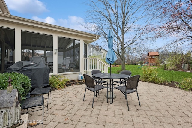 view of patio / terrace with a playground and a sunroom