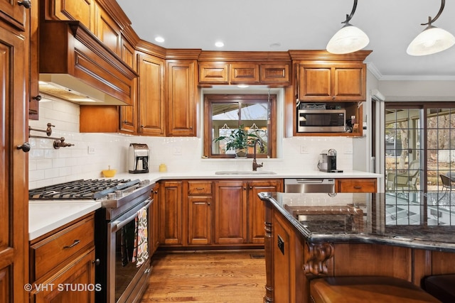 kitchen with a healthy amount of sunlight, stainless steel appliances, decorative light fixtures, and sink