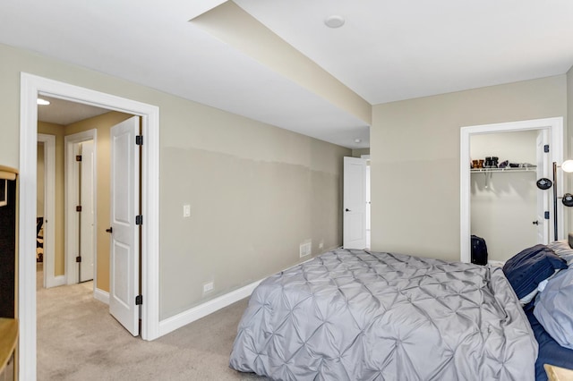 bedroom with light colored carpet, a spacious closet, and a closet