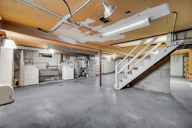 basement with stairway, washer / dryer, and a sink